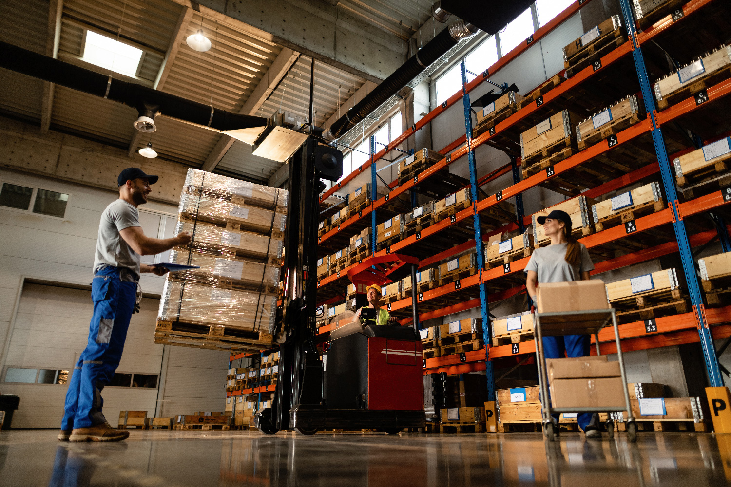 Waypoint 3PL staff picking from pallet racking, with a forklift moving stock behind them